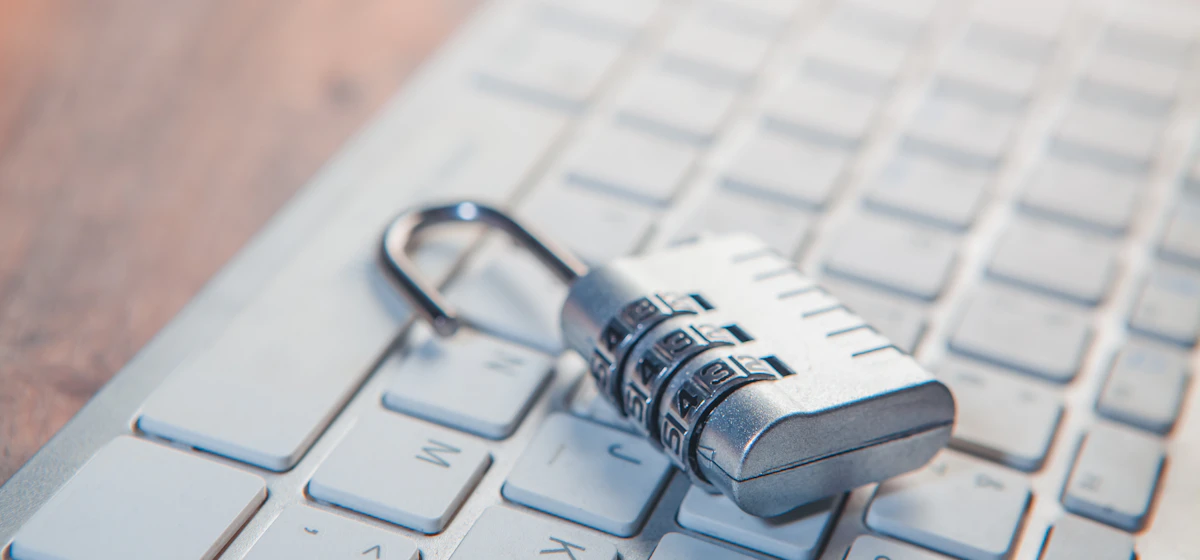 Combination padlock resting on a white computer keyboard