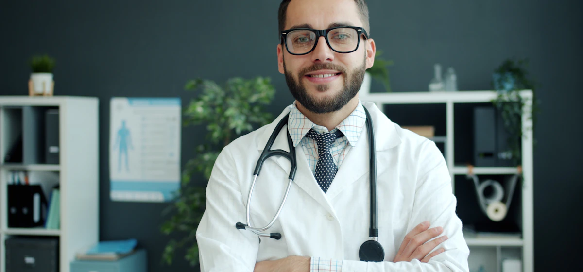 Smiling young doctor with stethoscope in a clinic office